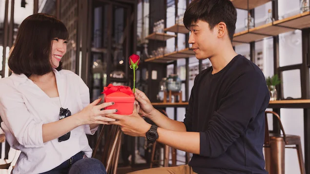 man-handing-gift-his-girlfriend-restaurant-3